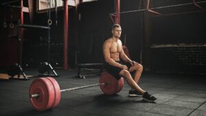 A professional athlete or gym-goer sitting resting between sets, looking composed rather than exhausted